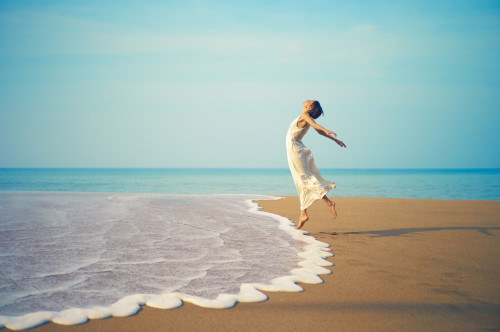 Young lady jumping on the beach
